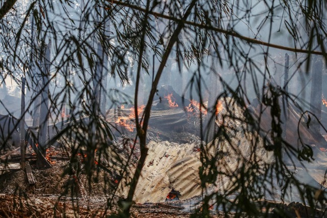 A smoldering house in Gawdu Tharya village