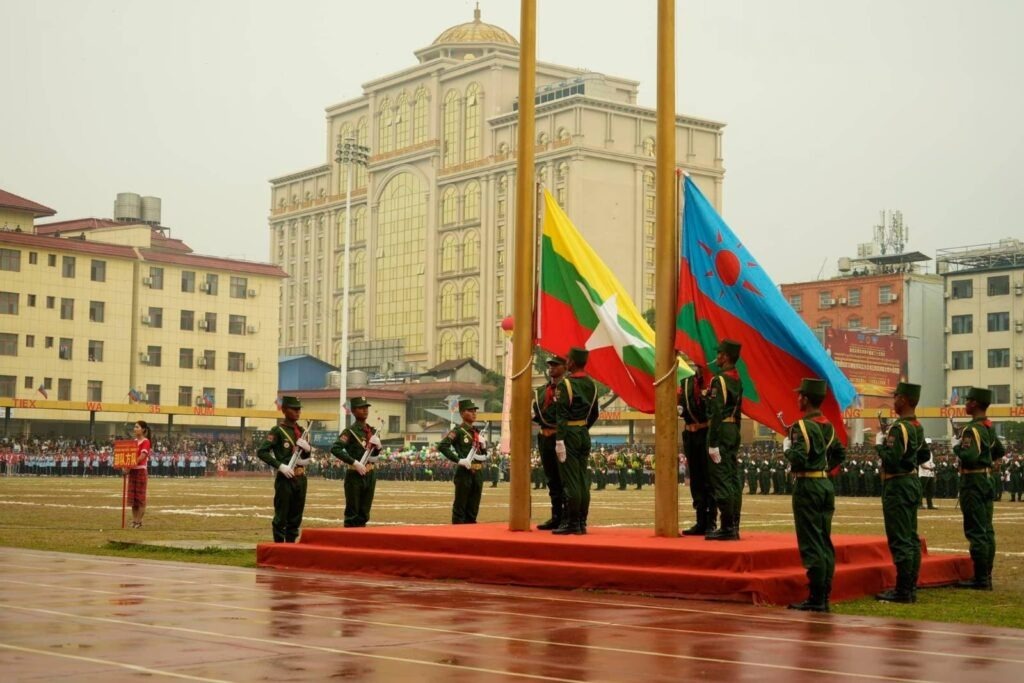 Members of the United Wa State Army (UWSA) hoist a flag