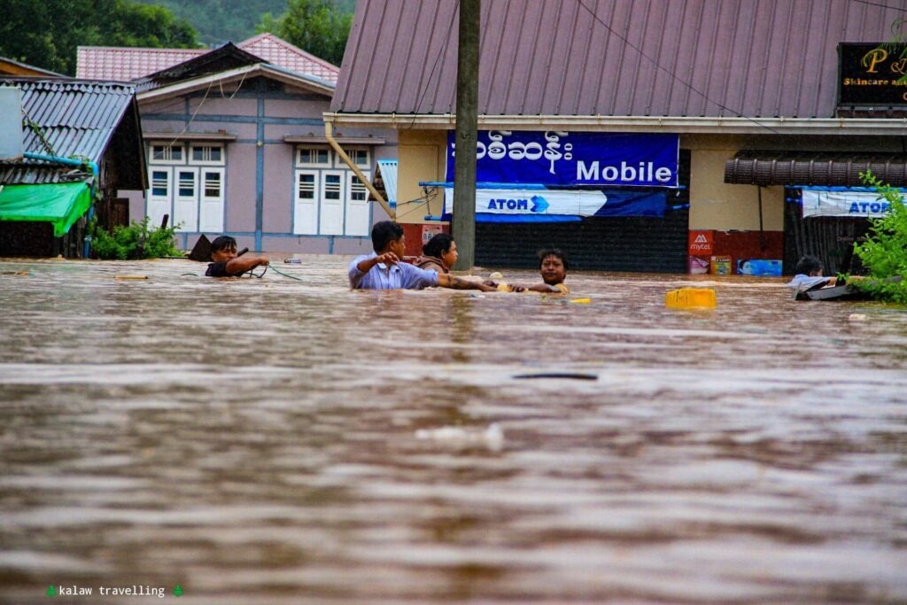 Residents wade through deep floodwaters during severe flooding